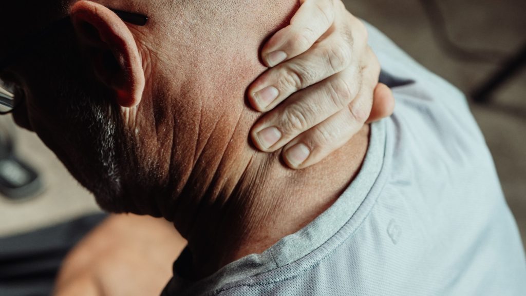 Person holding the back of the neck after an auto accident injury