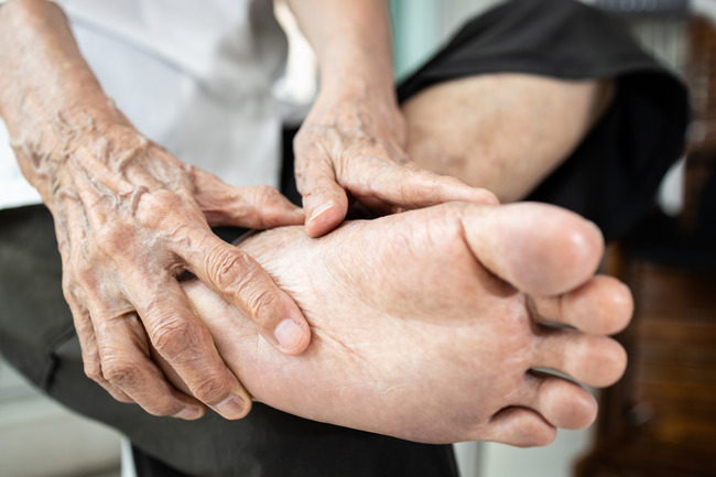 Older adult receiving a gentle foot assessment for chronic neuropathy