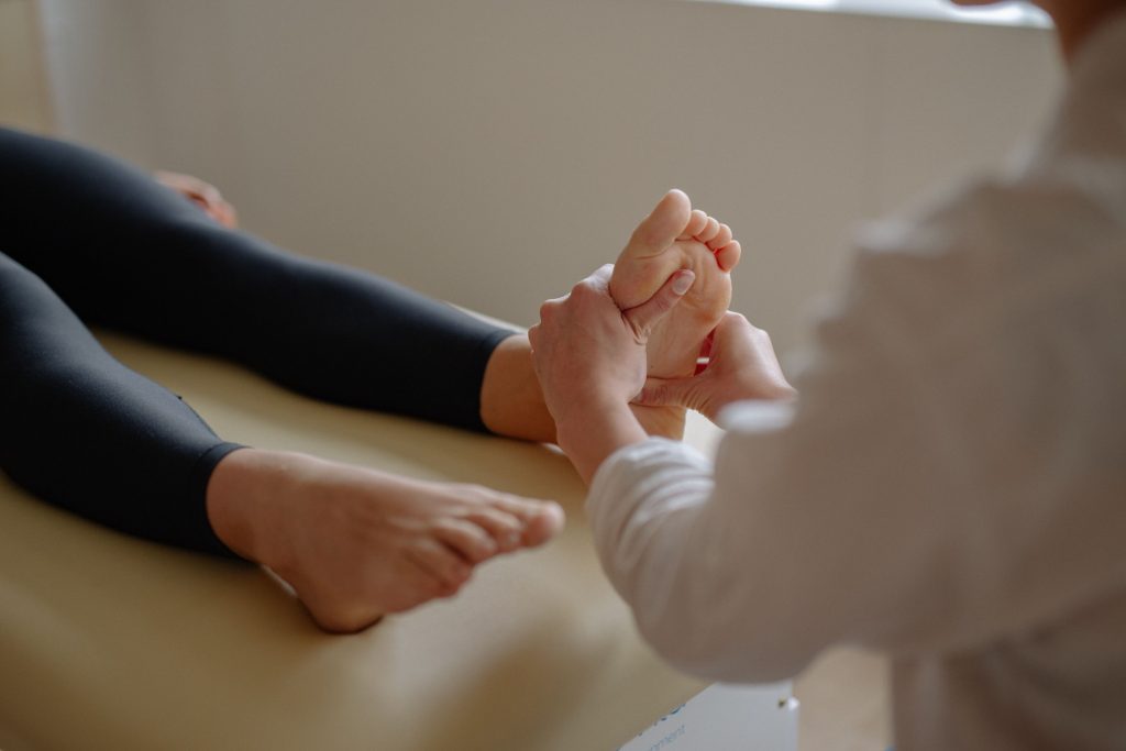 Clinician gently assessing a patient’s feet during a neuropathy visit