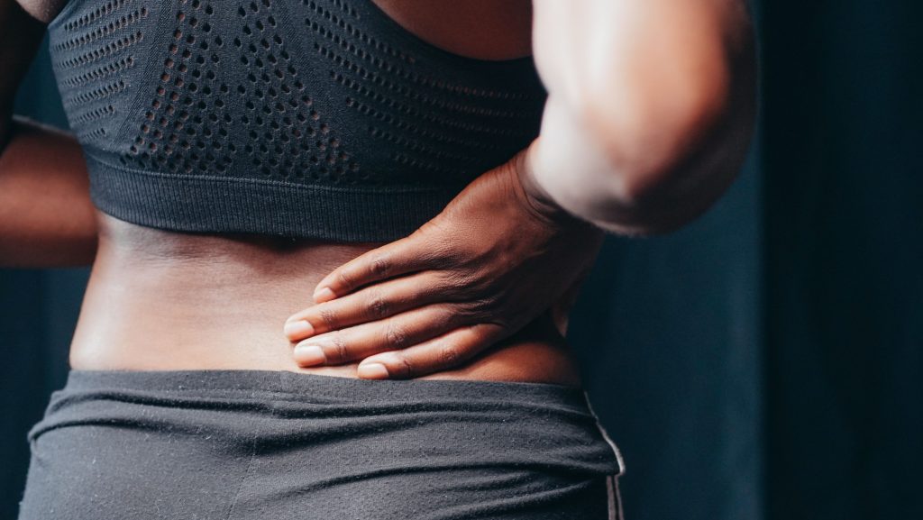 Person holding the lower back due to sciatic pain