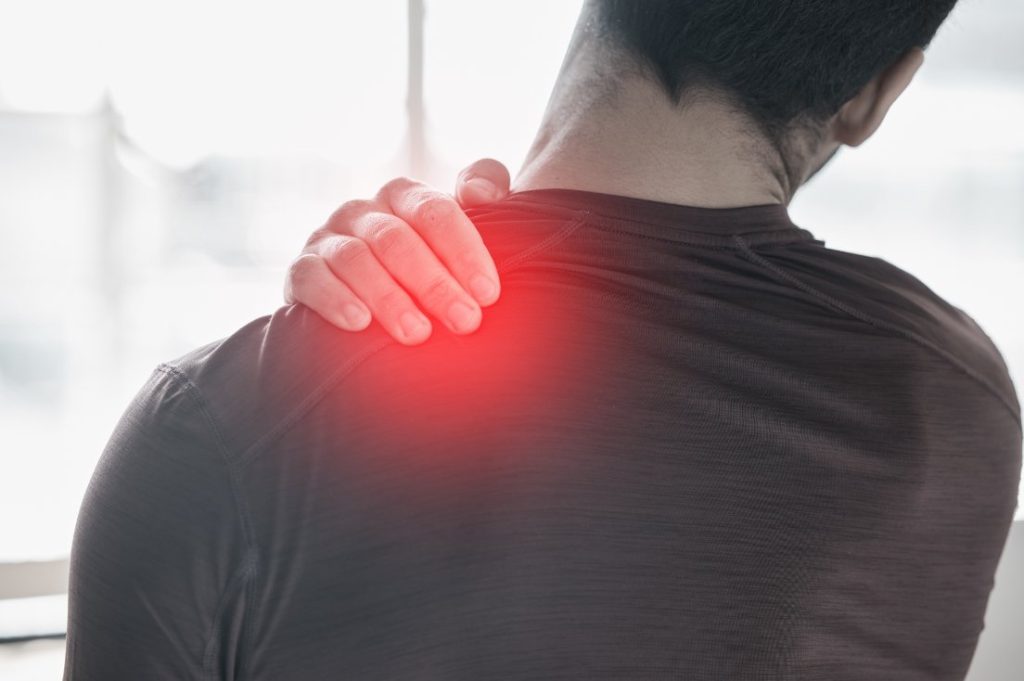 Person holding a painful shoulder