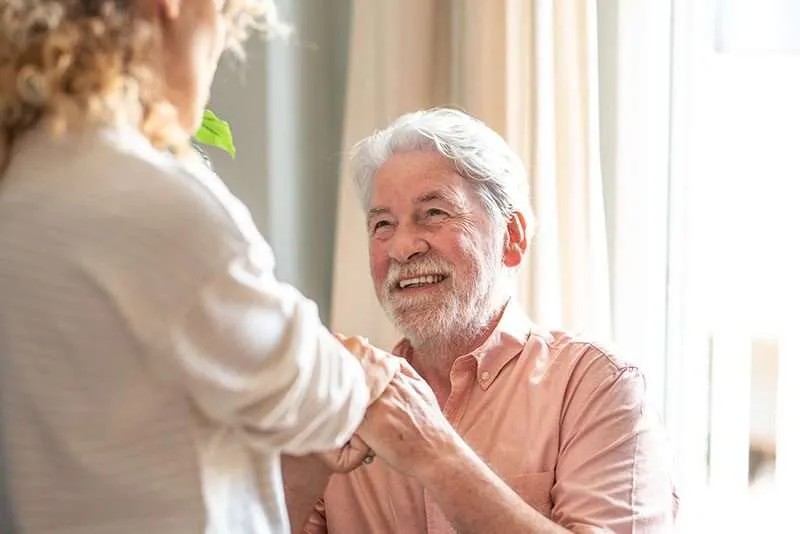 Older patient speaking with a care provider during recovery