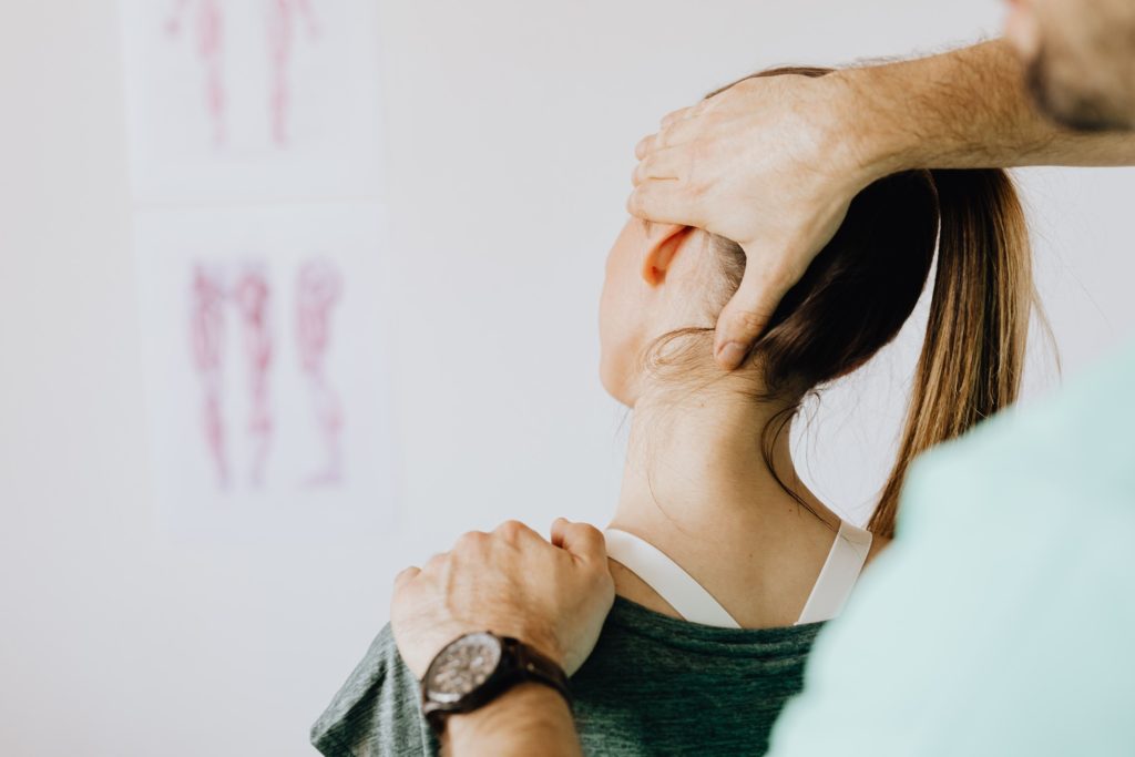 Clinician guiding an athlete through a neck mobility assessment
