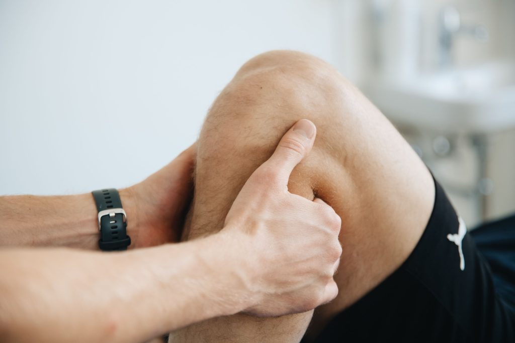 Athlete holding the knee during a sports injury assessment