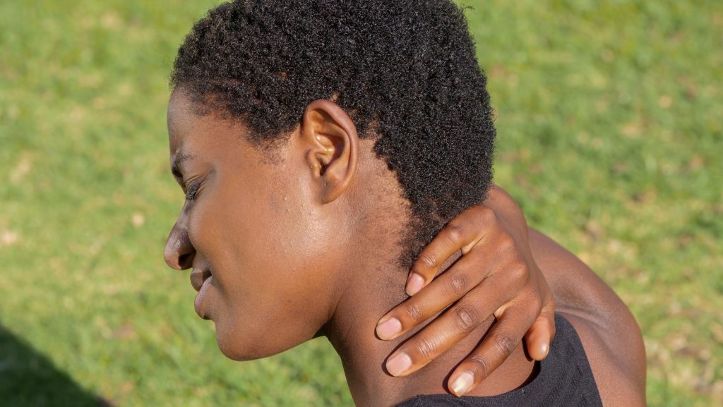 Person holding the side of the neck after a whiplash injury