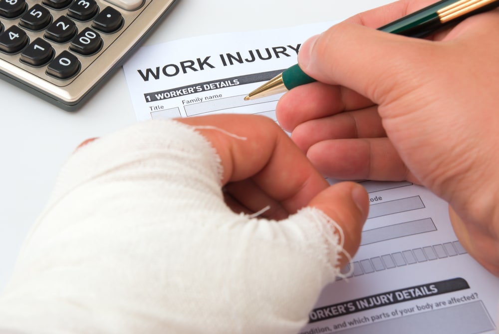 Bandaged worker completing a work injury report
