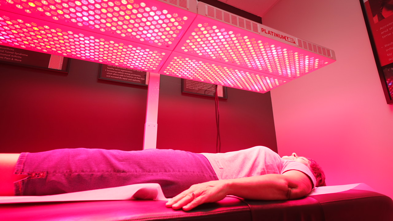 Patient lying beneath medical-grade red light therapy panels